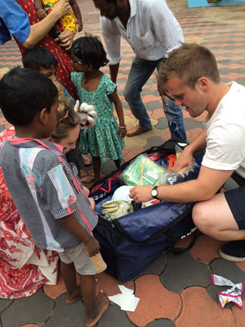 Ben Dickinson handing over some equipment to children in an orphanage in India.